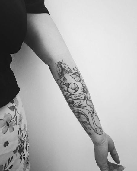 Tattoo of ladybug in a garden